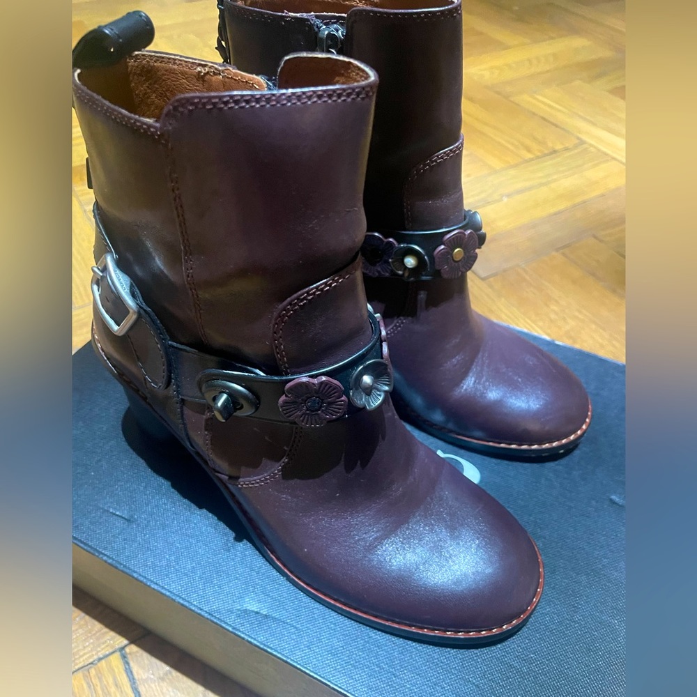 Coach moto booties in burgundy with leather flowers.